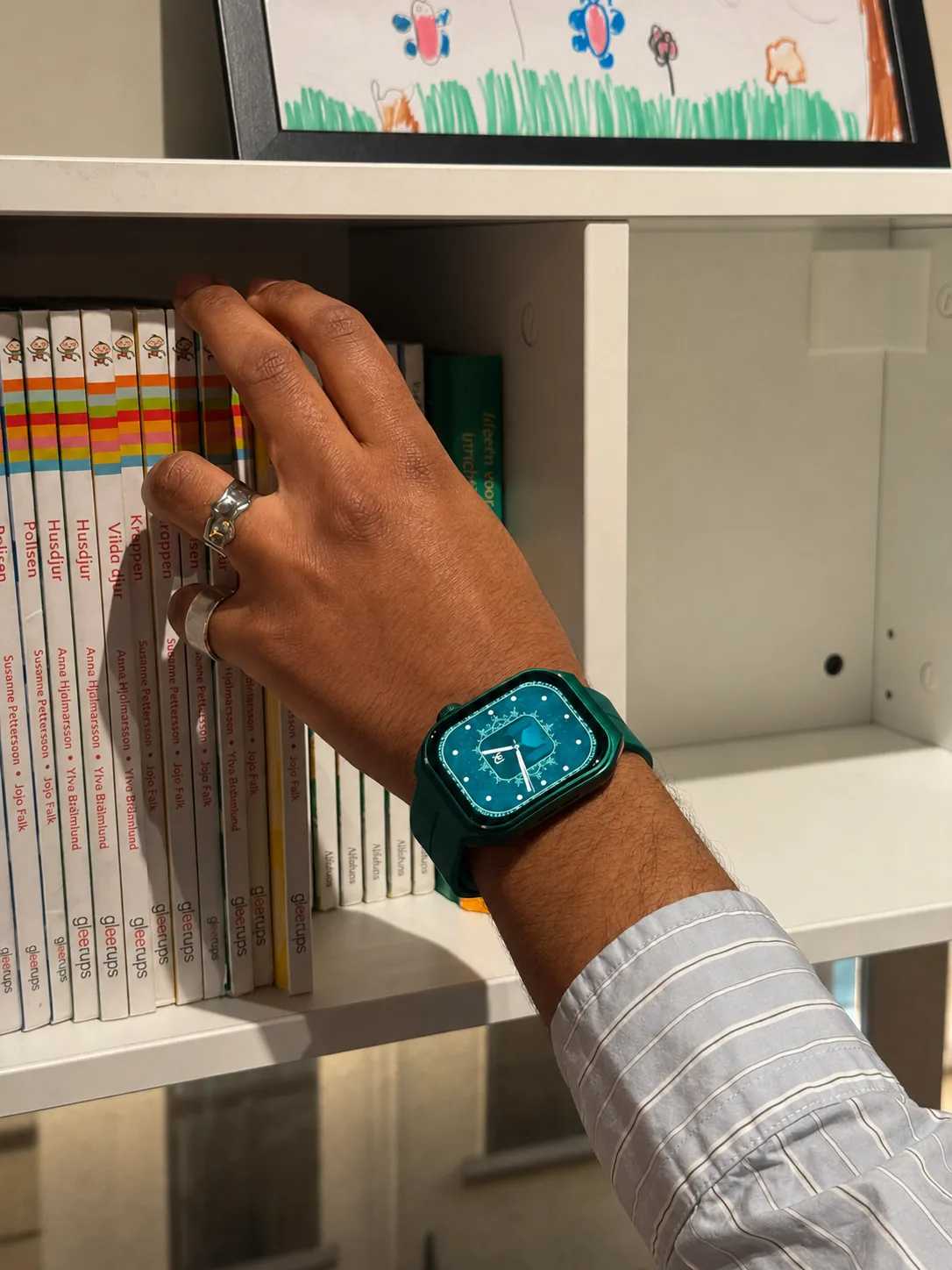 Original close-up of a green M2 Smartwatch while selecting a children's book