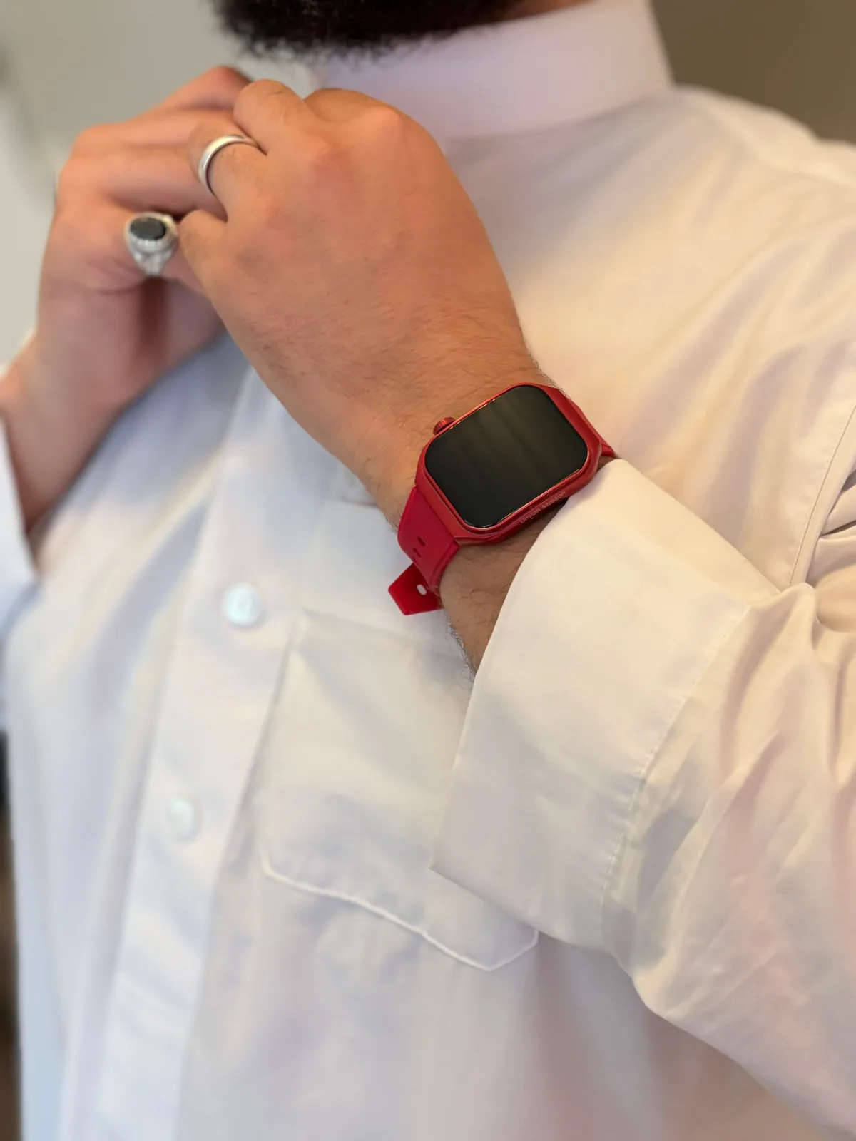 Original close-up of a red M2 Smartwatch worn with a white thobe